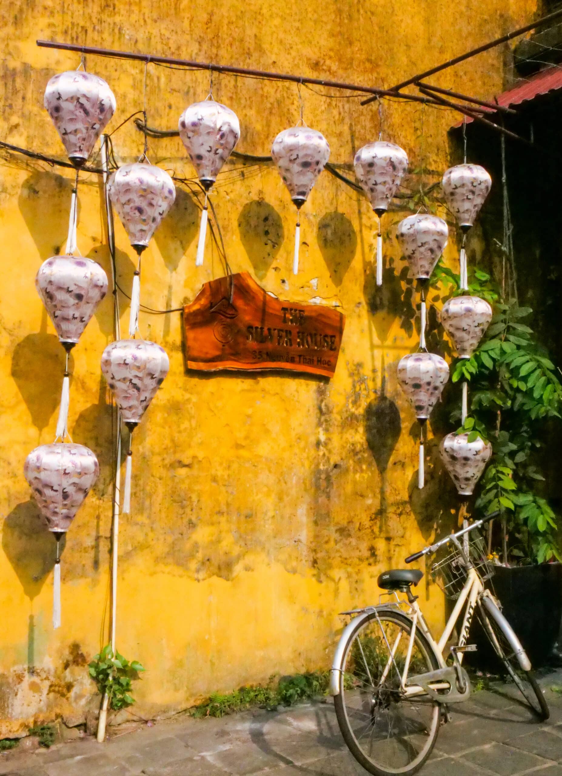 Mur jaune avec lanternes et vélo à Hoi An au Vietnam