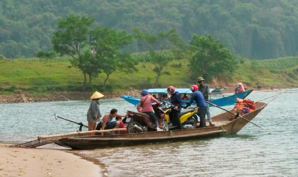 Scooters chargés sur une barque pour traverser la rivière de Phong Nha au Vietnam